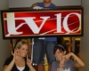 Students help install a sign with TV-10s new logo.